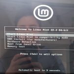 photo d'un écran d'ordinateur avec le menu proposant d'installer Linux Mint. On me voit dans le reflet de l'écran